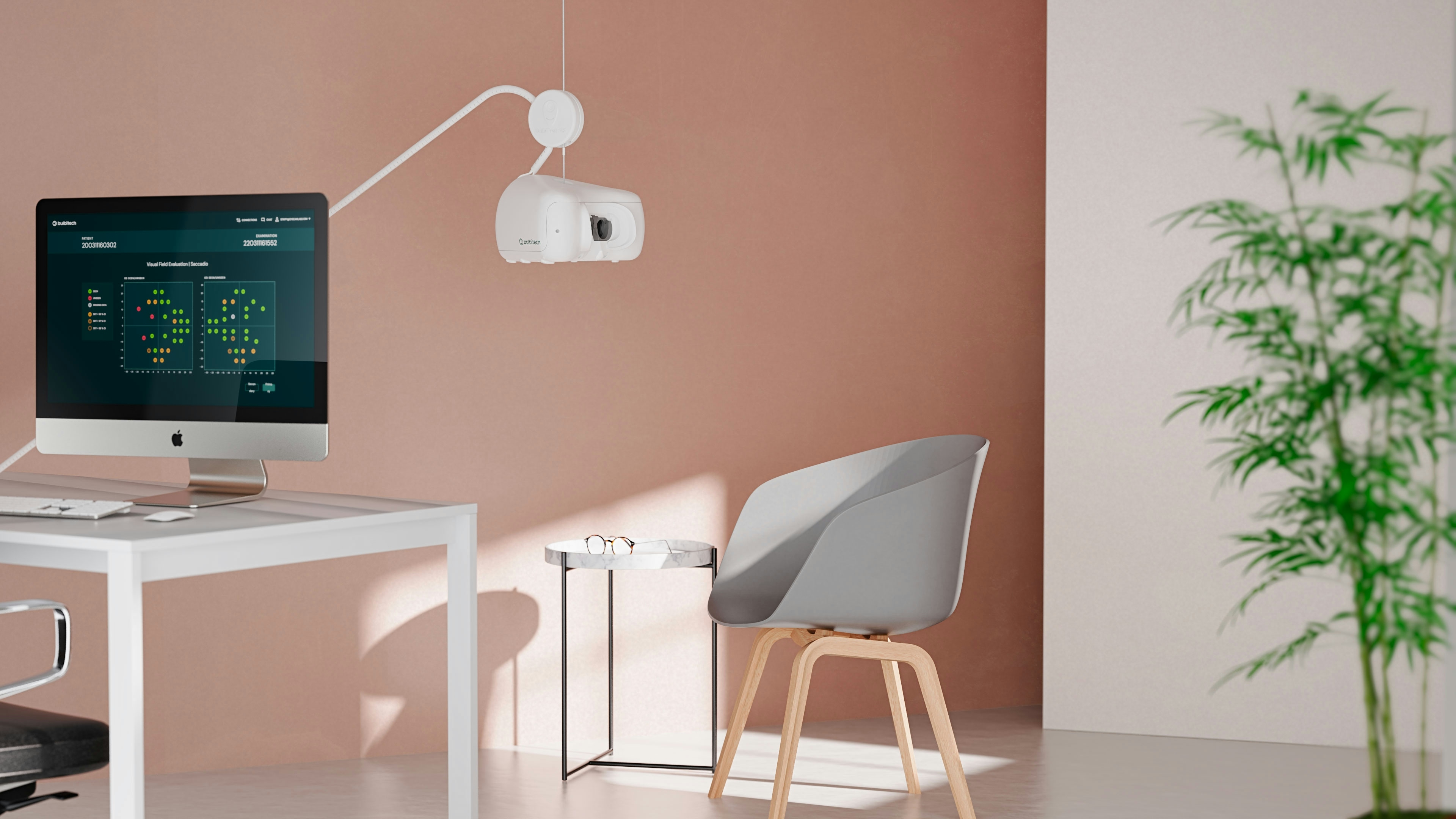 A white desk with a desktop screen showing a software program on the screen and an eye examination device hanging over the table. A gray chair in front of the desk. A light peach and a white coloured wall behind, as well as a green plant. Render. 